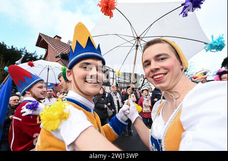 Herbstein, Allemagne. 12 février 2024. Une paire de sauteurs sourit à la procession de sauteurs Herbstein. Les tailleurs de pierre tyroliens ont apporté la tradition à Herbstein au XVIIe siècle. Plus de 50 chars ont pris part au traditionnel défilé Rose Monday dans la ville du district de Vogelsberg. Crédit : Uwe Zucchi/dpa/Alamy Live News Banque D'Images