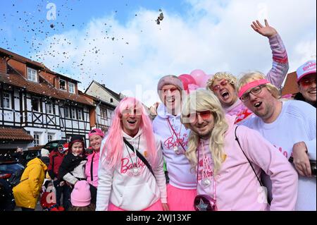 Herbstein, Allemagne. 12 février 2024. Un groupe de jeunes hommes en costumes Barbie sont de bonne humeur à la procession de sauteurs Herbstein. Les tailleurs de pierre tyroliens ont apporté la tradition à Herbstein au XVIIe siècle. Plus de 50 chars ont pris part au traditionnel défilé Rose Monday dans la ville du district de Vogelsberg. Crédit : Uwe Zucchi/dpa/Alamy Live News Banque D'Images