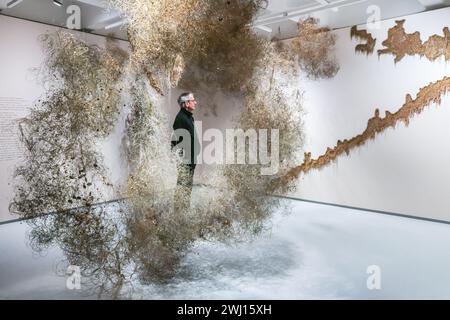 Barbican Art Gallery, Londres, Royaume-Uni. 12 février 2024. Personnel avec une gamme d'œuvres d'Igshaan Adams, y compris la pièce maîtresse d'or et d'argent Gebedswolke (nuage de prière), 2021-23. Allant de pièces intimes artisanales à des installations sculpturales à grande échelle, Unravel : The Power and Politics of textiles in Art rassemble plus de 100 œuvres de 50 praticiens internationaux qui utilisent des textiles, des fibres et des fils pour communiquer des idées sur le pouvoir, la résistance et la survie. Il fonctionne jusqu'au 26 mai 2024. Crédit : Imageplotter/Alamy Live News Banque D'Images