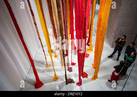 Londres, Royaume-Uni. 12 février 2024. Visiteurs avec 'Quipu Austral', 2012, de Cecilia Vicuña lors d'une avant-première de 'Unravel : The Power and Politics of textiles in Art', une nouvelle exposition à la Barbican Art Gallery qui explore le médium des textiles. Plus de 100 œuvres de 50 praticiens internationaux illustrant la couture, le tissage, le tressage, le perlage et le nouage sont exposées du 13 février au 26 mai 2024. Credit : Stephen Chung / Alamy Live News Banque D'Images