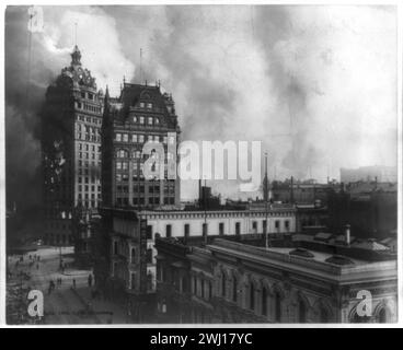 San Francisco 1906 tremblement de terre : catastrophe de San Francisco - tremblement de terre et incendie - plusieurs bâtiments au premier plan, un grand bâtiment sur le feu, d'autres bâtiments et de la fumée en arrière-plan Banque D'Images