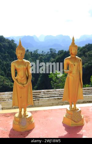 Province de Krabi, Thaïlande. Deux statues d'or de Bouddha au sommet du temple de la grotte du tigre. Banque D'Images