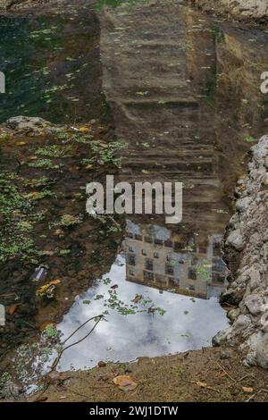 bâtiment reflété dans les eaux d'une rivière sous une grande falaise Banque D'Images
