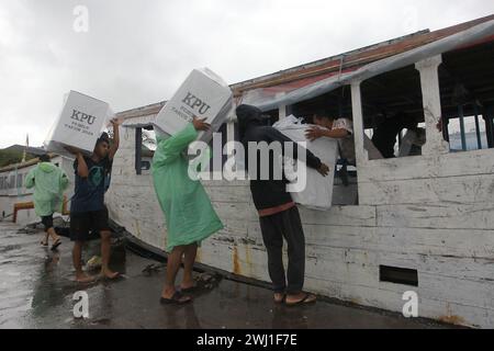 Makassar, Indonésie. 12 février 2024. Les travailleurs chargent les urnes sur un navire pour les livrer aux îles éloignées du port de Paotere à Makassar, Sulawesi du Sud, Indonésie, le 12 février 2024. Le pays se prépare à la journée des élections nationales prévue mercredi prochain pour choisir le leader du pays et les nouveaux membres du parlement. Crédit : Masyudi F./Xinhua/Alamy Live News Banque D'Images