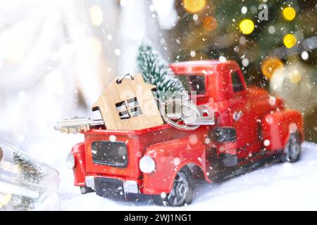 Voiture rétro rouge avec un arbre de Noël décorera avec la clé de la maison dans le pick-up pour Noël. Achat d'une maison, déménagement, morg Banque D'Images