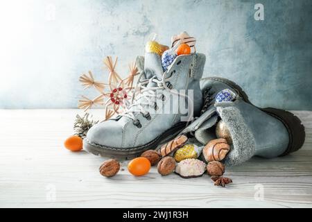 Nicholas Day ou en Allemagne Nikolaus Tag en décembre, bottes d'hiver remplies de friandises et de décoration de Noël contre un blu froid Banque D'Images