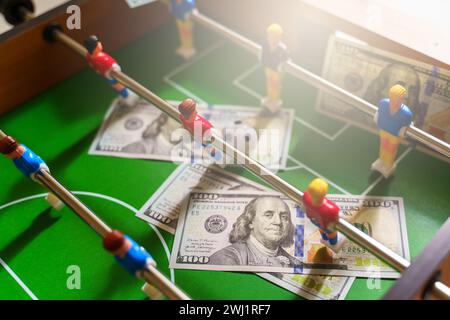 Jeu de baby-foot avec des billets de dollar américains dispersés autour d'elle, faisant allusion à un concept de pari Banque D'Images