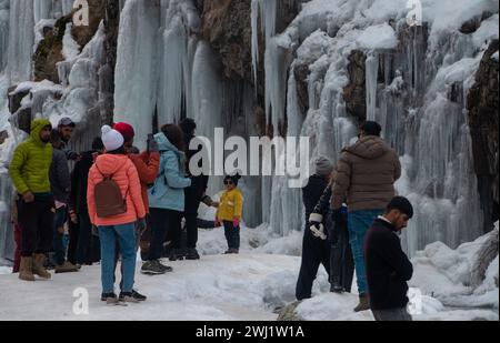 Baramulla, Jammu-et-Cachemire, Inde. 12 février 2024. Les gens explorent la spectaculaire chute de glace glacée drung par une froide journée d'hiver à Tangmarg, Baramulla. Drung, un petit village situé à environ 50 km de la capitale, Srinagar, devient une destination touristique populaire cet hiver en raison des températures inférieures au point de congélation dans la vallée. (Crédit image : © Adil Abbas/ZUMA Press Wire) USAGE ÉDITORIAL SEULEMENT! Non destiné à UN USAGE commercial ! Banque D'Images