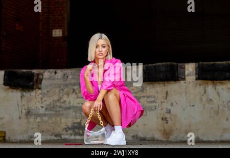 Un beau modèle Blonde pose en plein air tout en profitant de la météo printanière Banque D'Images