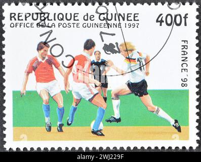 Timbre-poste annulé imprimé par la Guinée, qui montre les joueurs de football, faisant la promotion de la coupe du monde de la FIFA en France 98, vers 1997. Banque D'Images