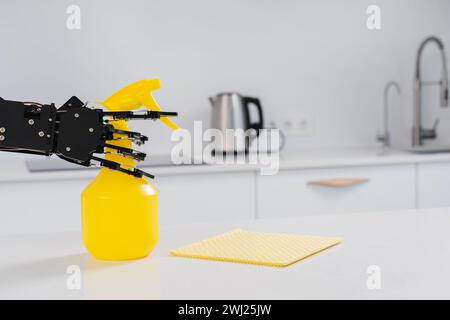 Vraie main de robot avec nettoyant en spray dans la cuisine blanche. Concept d'automatisation de processus robotique Banque D'Images