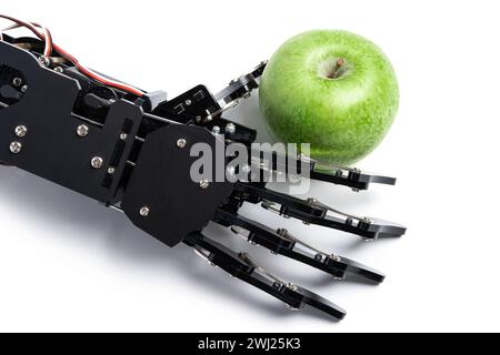 Main de vrai robot avec pomme verte. Concept de développement d'intelligence artificielle et d'automatisation de processus robotisés. Banque D'Images