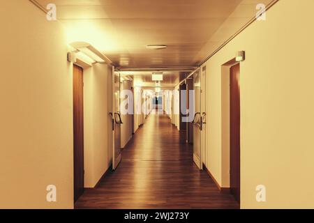 Long couloir éclairé, couloir, dans le bâtiment résidentiel, clinique, maison de retraite, Banque D'Images