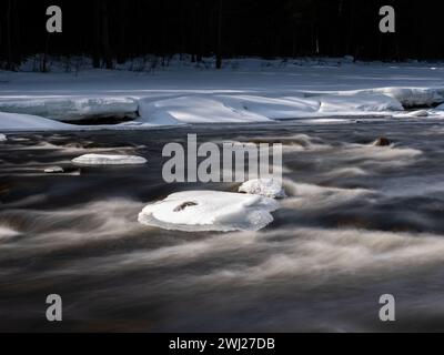 La glace se brise au printemps sur une rivière scandinave. Longue exposition pour une eau fluide. Tourné en Suède, en Europe Banque D'Images