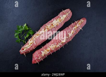 Filet de porc cru Mangalica farci de noix hachées et de citrouille offert comme vue de dessus sur un tableau noir design avec copie spa Banque D'Images