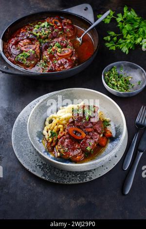 Ossobuco alla milanese traditionnel braisé avec gremolata et spaetzle servi dans une assiette au design nordique Banque D'Images