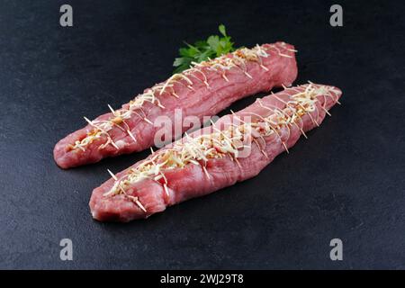 Filet de porc cru Mangalica farci de noix hachées et de citrouille offert en gros plan sur un tableau noir avec copie spa Banque D'Images