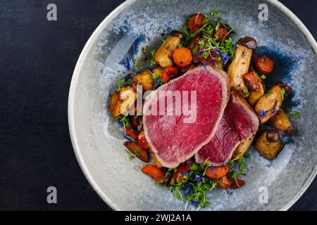 Steak de filet de bœuf chianina italien frit très rare avec champignons et carottes servis comme vue de dessus dans un bol design nordique avec co Banque D'Images