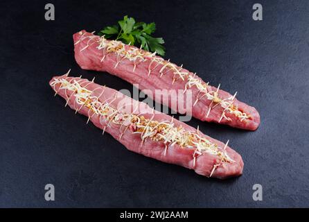 Filet de porc cru Mangalica farci de noix hachées et de citrouille offert en gros plan sur un tableau noir avec copie spa Banque D'Images
