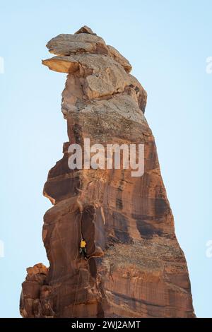 Vue à angle bas de l'alpiniste grimpant falaise rocheuse contre le ciel Banque D'Images