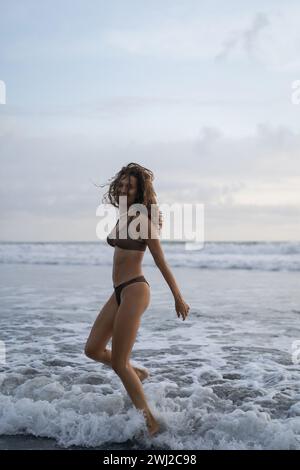 Portrait de jeune joyeuse femme de cheveux bouclés heureuse sur l'océan. Bali Banque D'Images