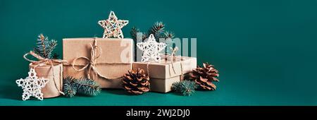 Boîte-cadeaux durable de Noël composition et décor naturel sur bannière bleue verte. Noël zéro déchet, jour de boxe et hiver Banque D'Images