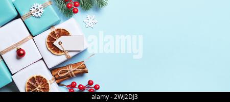 Coffrets cadeaux emballés dans du papier, décorés avec des boules et de la ficelle. Bannière bleue d'emballage cadeau de Noël écologique Banque D'Images