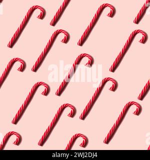 Texture de Noël sans couture faite de canne de bonbons aléatoires et chapeau de Père Noël sur fond rose Banque D'Images