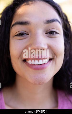 Gros plan portrait de femme biraciale heureuse dans la nature ensoleillée Banque D'Images