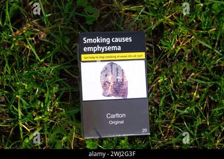 Paquet de cigarettes mis au rebut sur fond d'herbe avec poumon malade causé par le tabagisme affichant un avertissement d'emphysème au Royaume-Uni KATHY DEWITT Banque D'Images