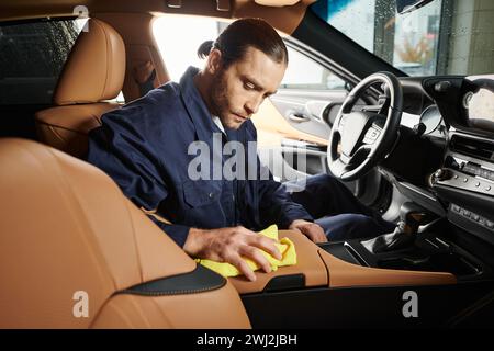 attirant militaire dévoué en uniforme bleu avec voiture de nettoyage de cheveux collectée avec chiffon jaune Banque D'Images