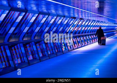 Des personnes interagissant avec l’œuvre d’art contemporain publique géométrique captivée par Colour par l’artiste Camille Walala dans la passerelle du tunnel à Adams Plaza Bridge reliant North Collonade à Crossrail place au cœur du quartier financier de Canary Wharf le 6 février 2024 à Londres, Royaume-Uni. Canary Wharf est une zone située près de l'île des chiens dans le quartier londonien de Tower Hamlets et est définie par la Greater London Authority comme faisant partie du quartier central des affaires de Londres. Banque D'Images