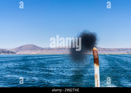 Plume une suie noire provenant du tuyau d'échappement d'un bateau touristique sur le lac titicaca Banque D'Images