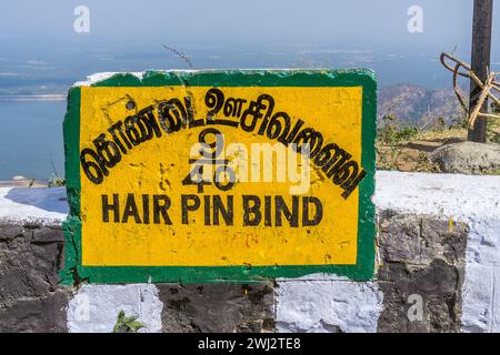 Un panneau indiquant le 9ème virage en épingle à cheveux sur la route de Pollachi à Valparai avec le réservoir Aliyar en arrière-plan. Banque D'Images