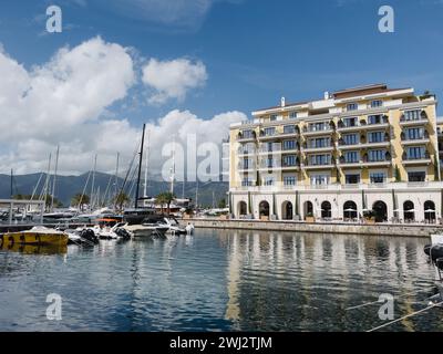Tivat, Monténégro - 11 août 2023 : remblai de l'hôtel Regent avec des arbres verts dans des baignoires près de la marina avec des yachts Banque D'Images