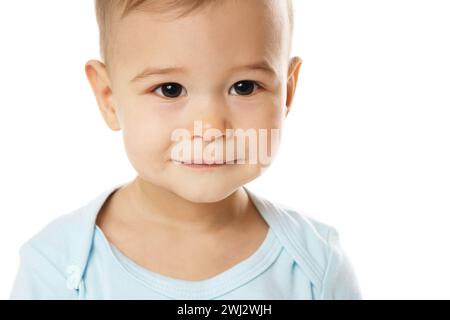 Gros plan du visage souriant d'un petit garçon en barboteuse. Banque D'Images