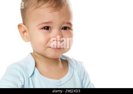 Plan en closeuo du visage d'un petit garçon pleurant en barboteuse. Banque D'Images