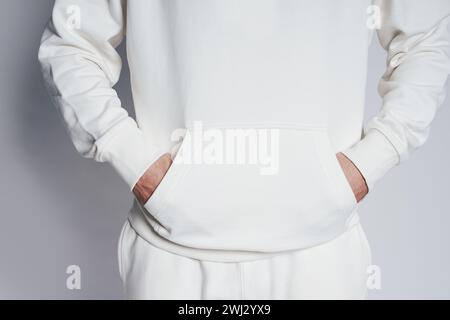 Homme portant un sweat à capuche blanc vierge sur fond gris Banque D'Images