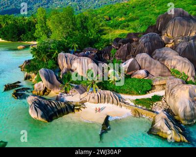 Anse Source d'argent, la Digue Seychelles, jeune couple hommes et femme sur une plage tropicale pendant des vacances de luxe dans la Seyche Banque D'Images