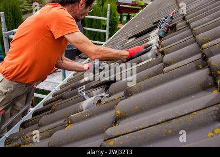 Couvreur, ouvrier sur le toit. Travaux de toiture. Installation de cellules solaires. Préparation du panneau solaire Banque D'Images