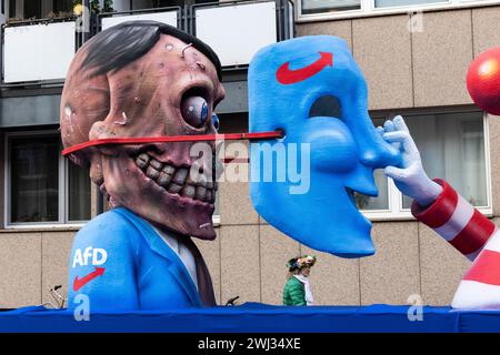 Düsseldorf, Deutschland. 12. Février 2024. Défilé du carnaval Rose Monday à Düsseldorf. Flotteur conçu par Jacques Tilly. AFD, Alternative für Deutschland. Caché derrière le masque, Hitler apparaît. Banque D'Images