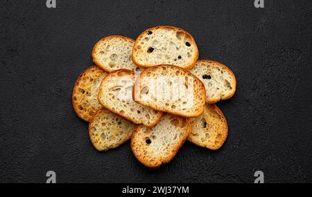 Crackers bruschetta, croûtons de pain sur fond noir, vue de dessus Banque D'Images