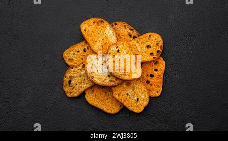 Crackers bruschetta, croûtons de pain sur fond noir, vue de dessus Banque D'Images