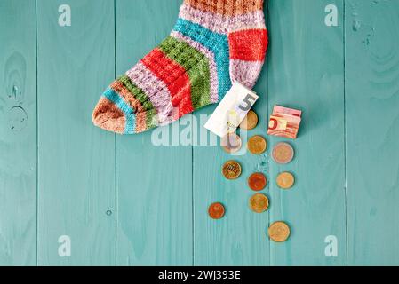 Chaussette de sauvetage. Des pièces se déversent de la chaussette en laine. euro argent dans la chaussette. épargne-retraite et cachette Banque D'Images