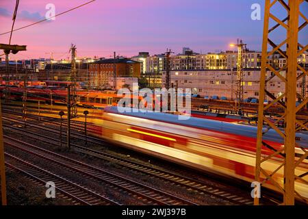 Vue en grand angle des voies avec un train en mouvement au coucher du soleil, Francfort-sur-le-main, Allemagne, Europe Banque D'Images
