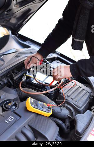 L'invention concerne un mécanicien automobile inspectant une voiture au moyen d'un dispositif de diagnostic électronique Banque D'Images