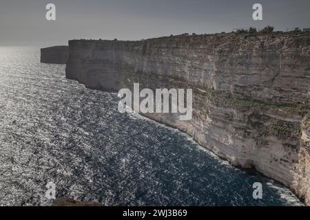 Le coucher de soleil sur l'océan avec une belle lumière du soleil dans les falaises de Ta Cenc à Malte Banque D'Images