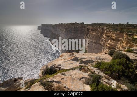 Le coucher de soleil sur l'océan avec une belle lumière du soleil dans les falaises de Ta Cenc à Malte Banque D'Images