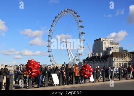 Rouge, Valentine Heart ballons vendus sur Westminster Bridge avec le London Eye derrière, février 2024, Royaume-Uni Banque D'Images