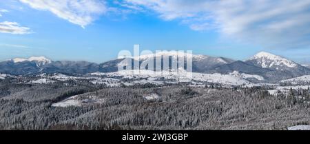 En hiver, les environs isolés des villages alpins, les collines de campagne, les bosquets et les terres agricoles offrent une vue depuis les pentes de montagne Banque D'Images